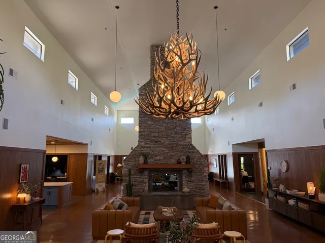 a living room with furniture a fireplace and a chandelier