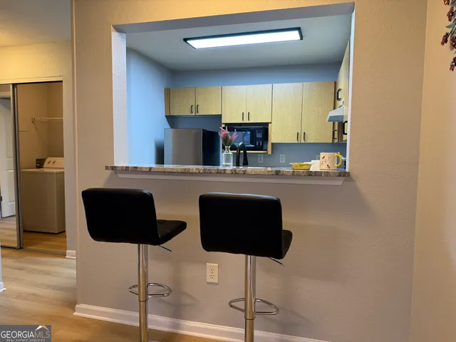 a kitchen with granite countertop a counter space and chairs