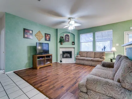 a living room with furniture a flat screen tv and a fireplace