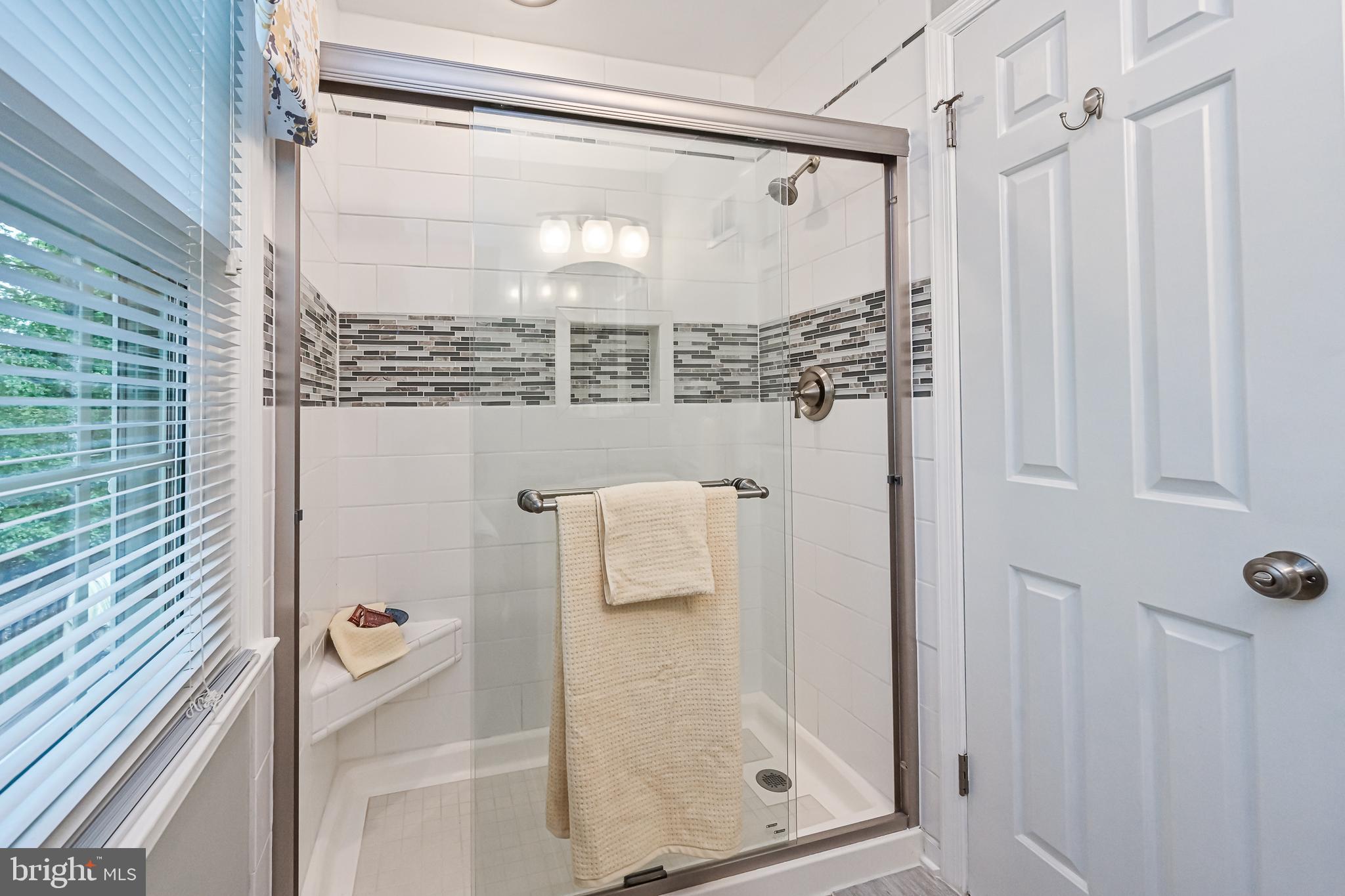 9010 Parliament Drive Burke, VA 22015 - Photo 21 of 40 Glass enclosed shower with decorative tilework