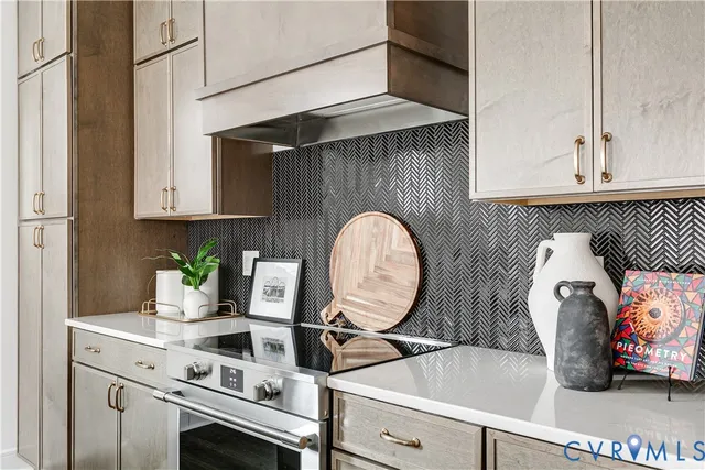 a kitchen with a sink and a stove with white cabinets