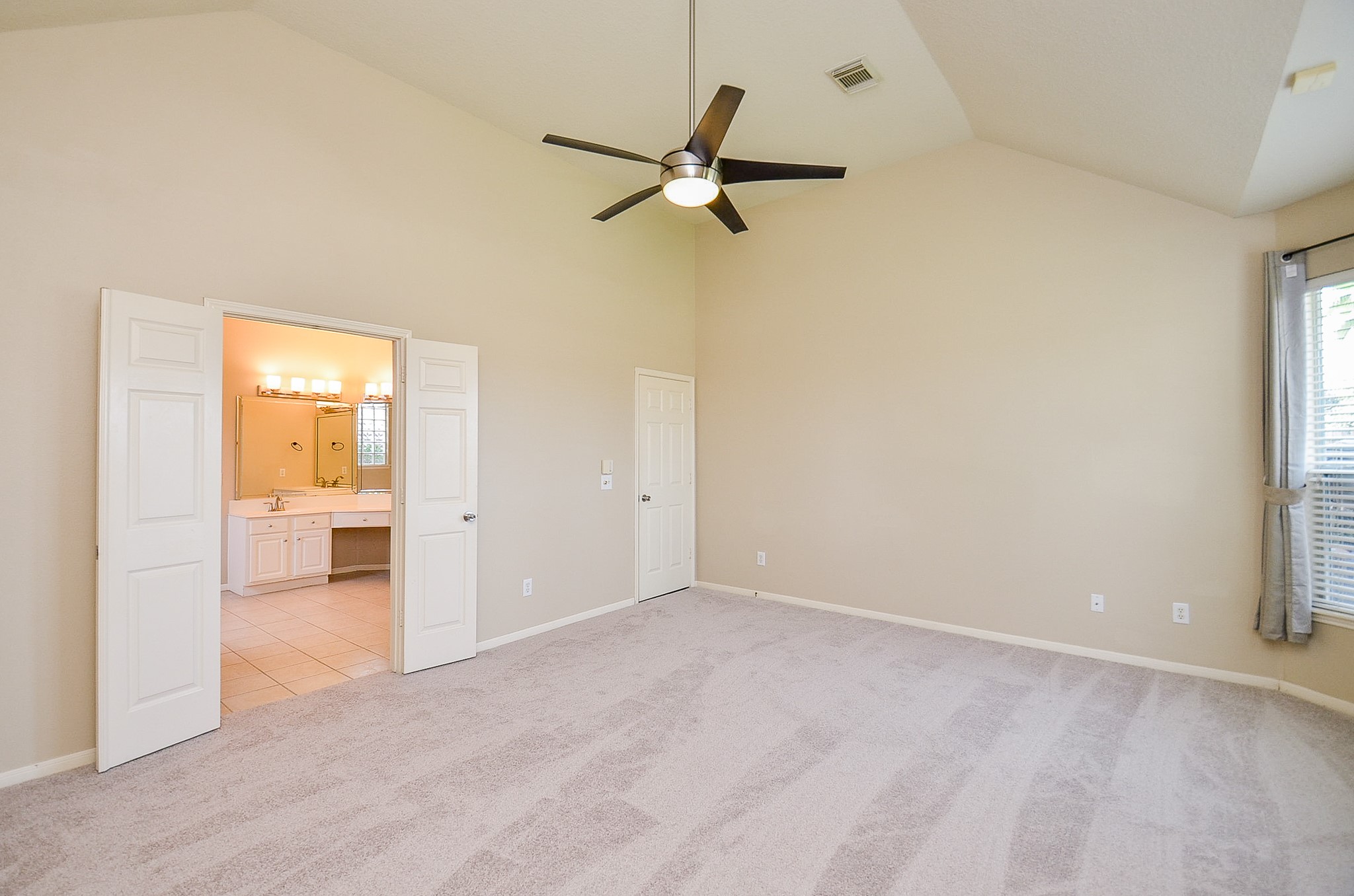 1222 Ragsdale Lane Katy, TX 77494 - Photo 17 of 31 Second view showing entry into the primary bath and the bedroom access door to the hall. The cathedral style ceiling adds dimension to the room.
