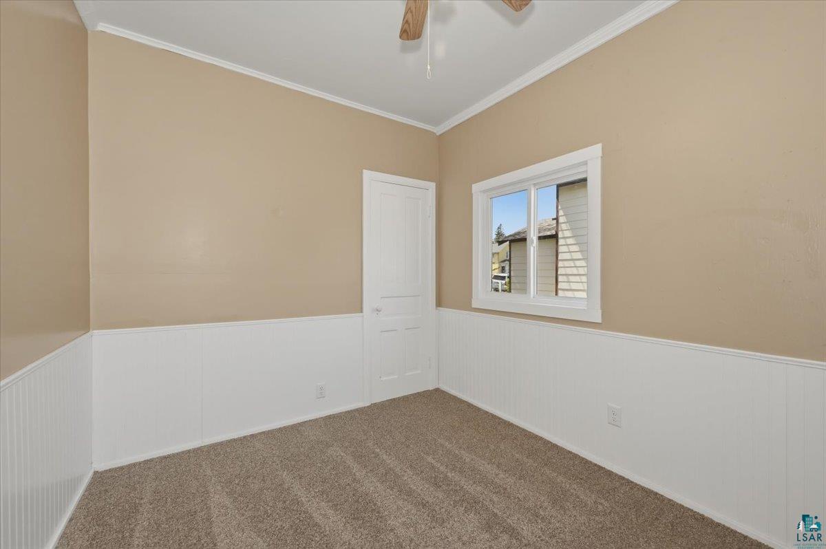 5319 East 3rd Street Superior, WI 54880 - Photo 14 of 33 Carpeted room featuring white wainscoting, neutral wall paint, and a white-trimmed window