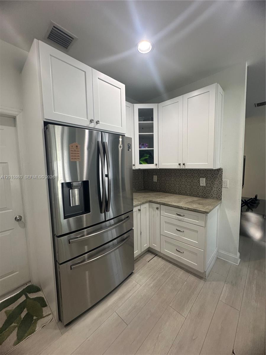 5402 Pointe Villa Drive, Unit B Lighthouse Point, FL 33064 - Photo 15 of 35 a kitchen with granite countertop white cabinets and stainless steel appliances