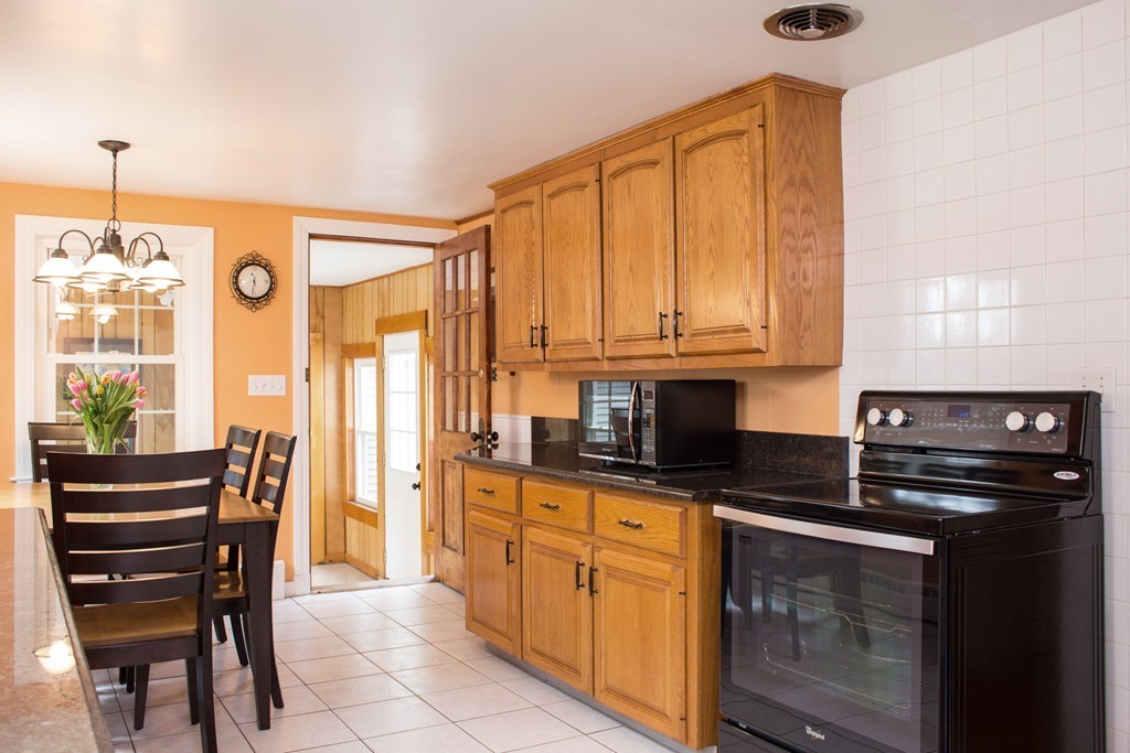 75 William Street Walpole, MA 02081 - Photo 4 of 27 a kitchen with granite countertop a stove a sink and a refrigerator