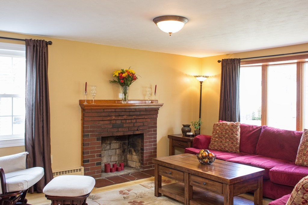 75 William Street Walpole, MA 02081 - Photo 8 of 27 a living room with furniture a fireplace and a large window