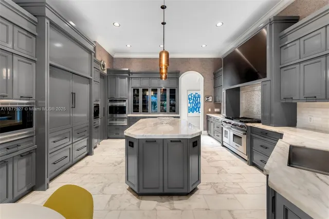 a kitchen with stainless steel appliances kitchen island granite countertop a stove a sink and a refrigerator