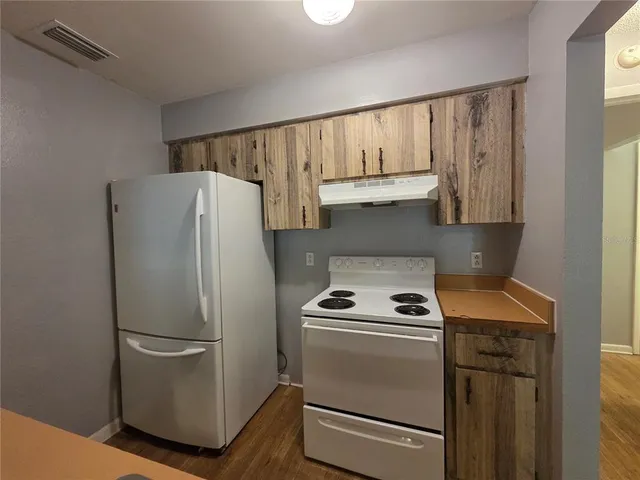 a white refrigerator freezer and a stove sitting inside of a kitchen