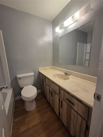 a bathroom with a granite countertop toilet sink and mirror