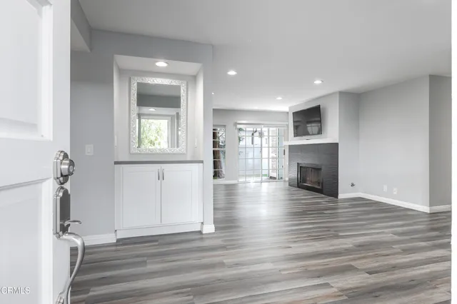 an empty room with wooden floor and a fireplace