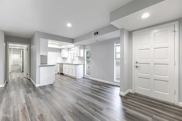 a view of a kitchen with wooden floor and electronic appliances
