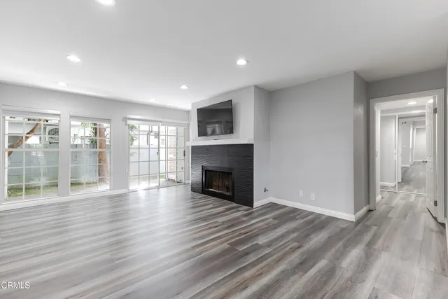 a view of empty room with wooden floor and fireplace
