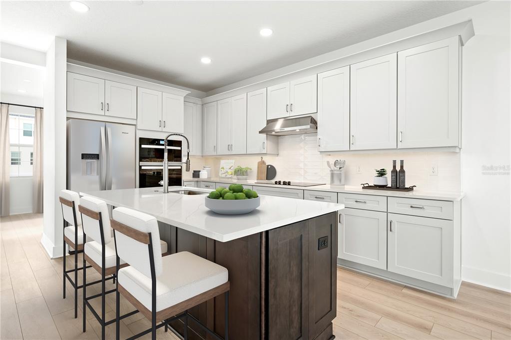 9973 Key Haven Road Seminole, FL 33777 - Photo 7 of 59 a kitchen with white cabinets and stainless steel appliances