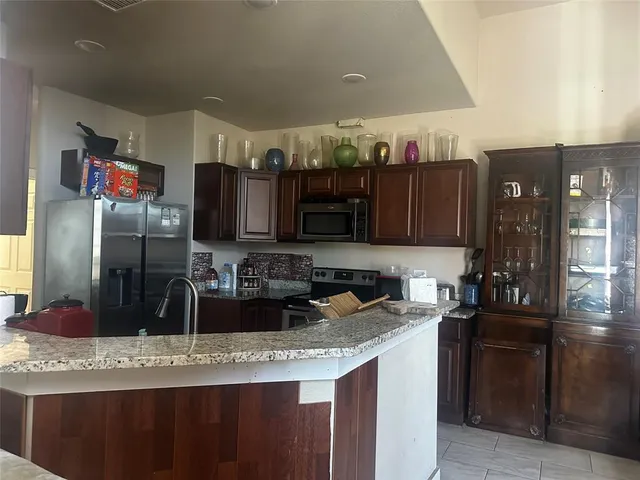 a kitchen with stainless steel appliances granite countertop a sink and a refrigerator
