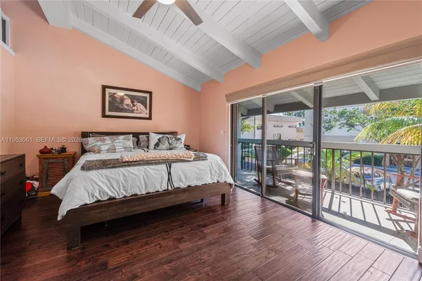 a bed sitting in a spacious bedroom next to a window