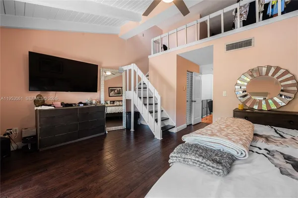 a living room with a bed and a flat screen tv