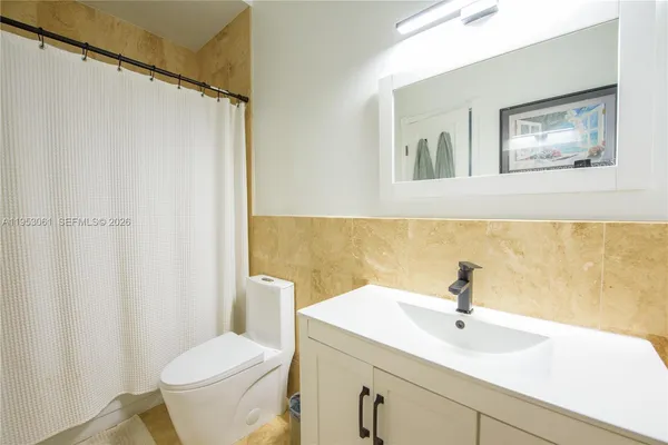 a bathroom with a sink a toilet and a mirror