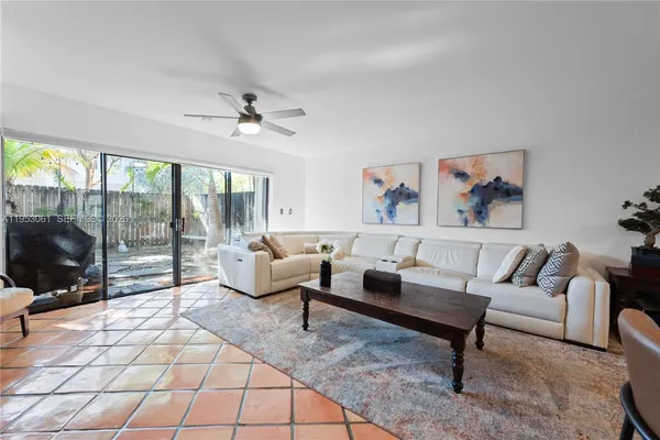 a living room with furniture and a floor to ceiling window