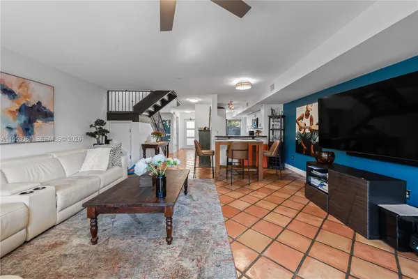 a living room with furniture a flat screen tv and kitchen view