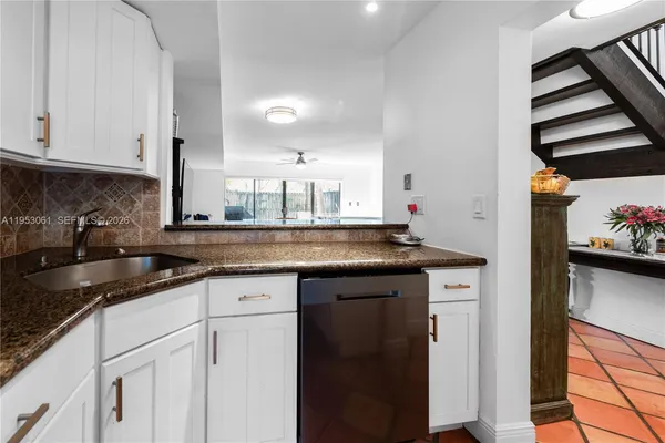 a kitchen with granite countertop a sink and cabinets