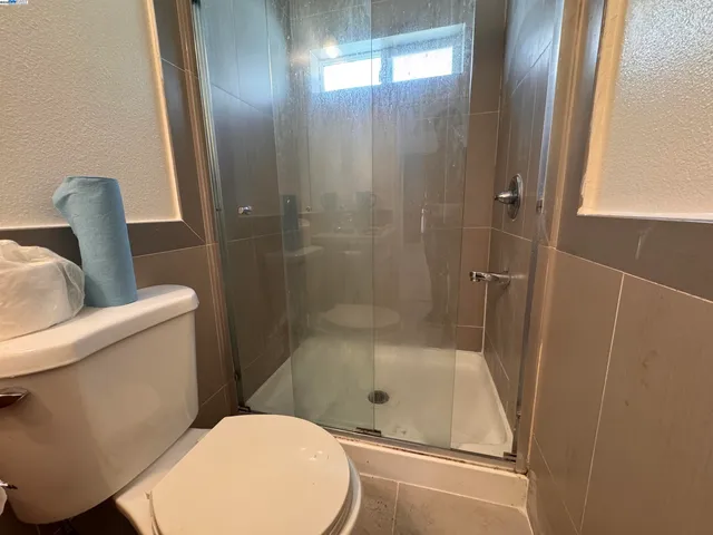 a bathroom with a toilet and a shower
