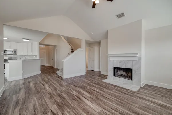 a view of a livingroom with wooden floor and a kitchen