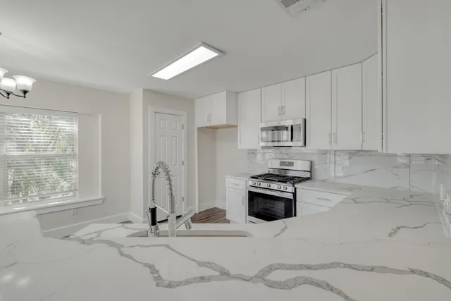 a kitchen with granite countertop a stove and a refrigerator