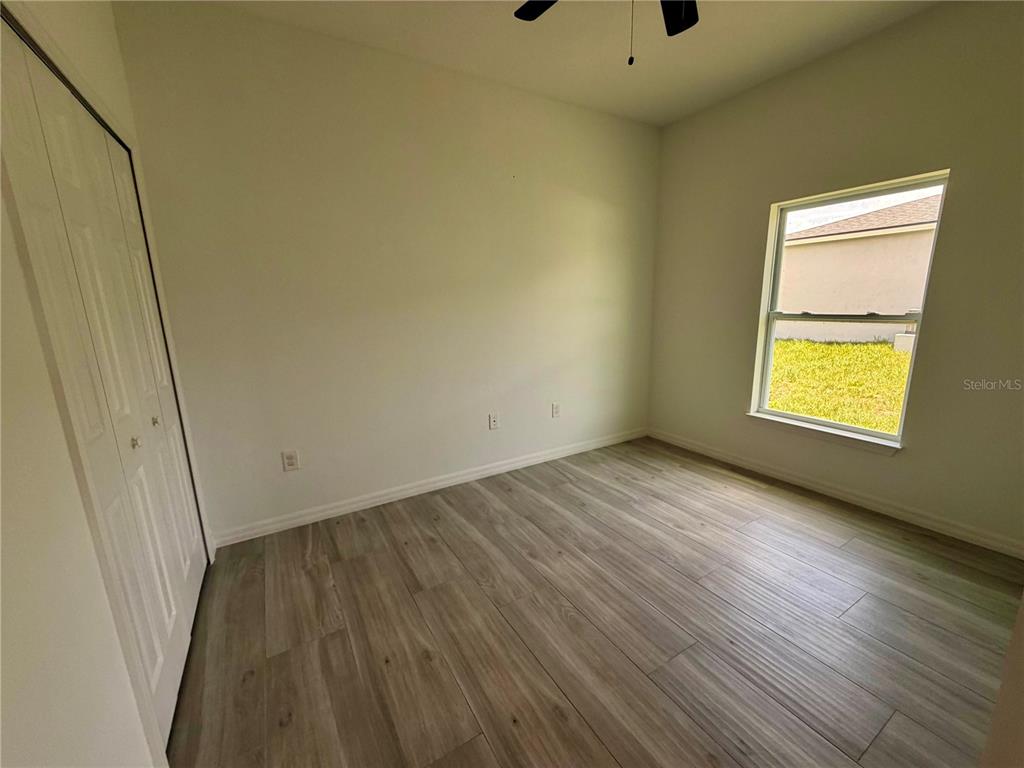 14142 Appleton Boulevard Port Charlotte, FL 33981 - Photo 22 of 26 an empty room with wooden floor and windows