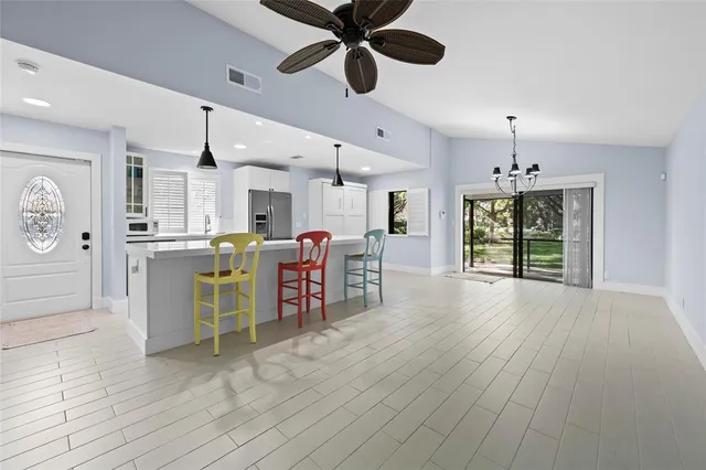 a open kitchen with stainless steel appliances kitchen island granite countertop a refrigerator cabinets and wooden floor