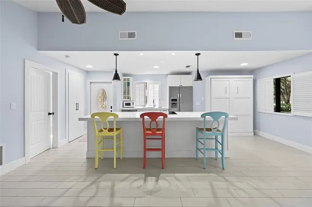 a dining room filled chandelier and kitchen view