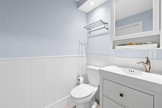 a bathroom with a toilet a sink and mirror