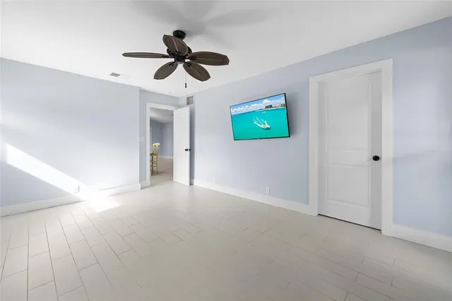 a view of empty room with window and ceiling fan