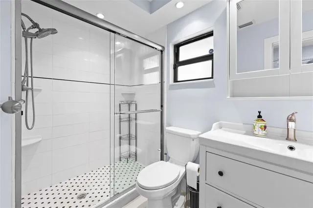 a bathroom with a sink a toilet and shower