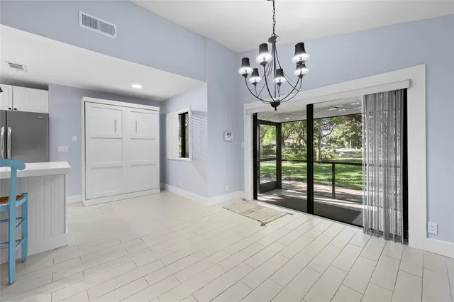 a view of a livingroom with a chandelier curtains and a chandelier