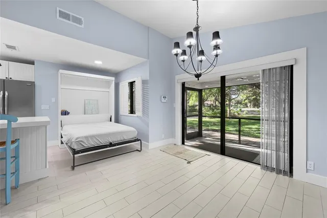 a spacious bedroom with a large bed and a chandelier