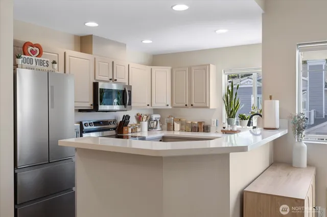 a kitchen with kitchen island a sink stove and refrigerator