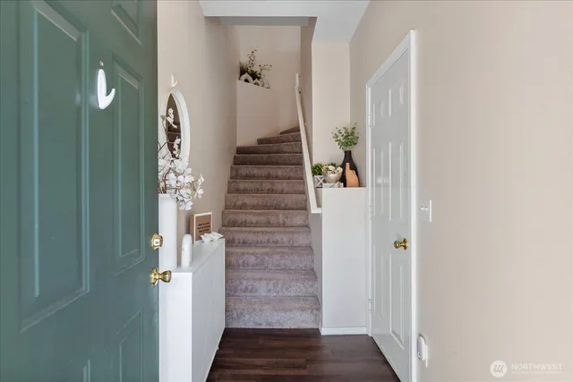 a view of a hallway with wooden floor and entryway