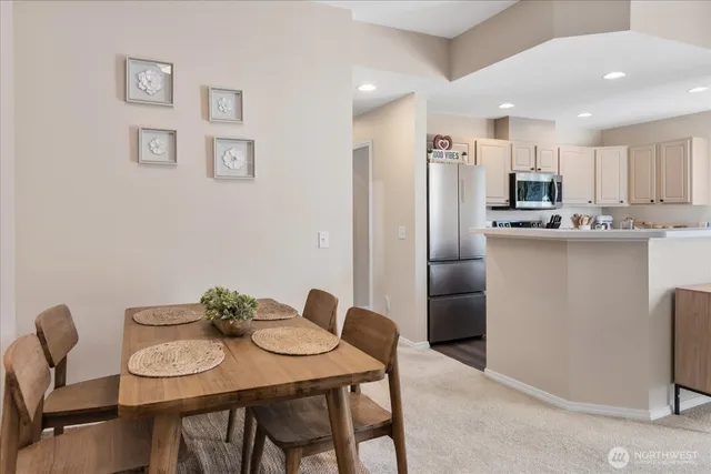 a kitchen with stainless steel appliances kitchen island granite countertop a dining table and chairs