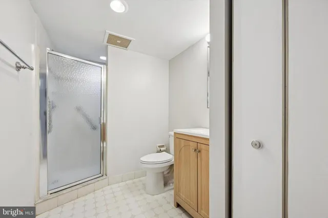 a bathroom with a granite countertop toilet and a shower