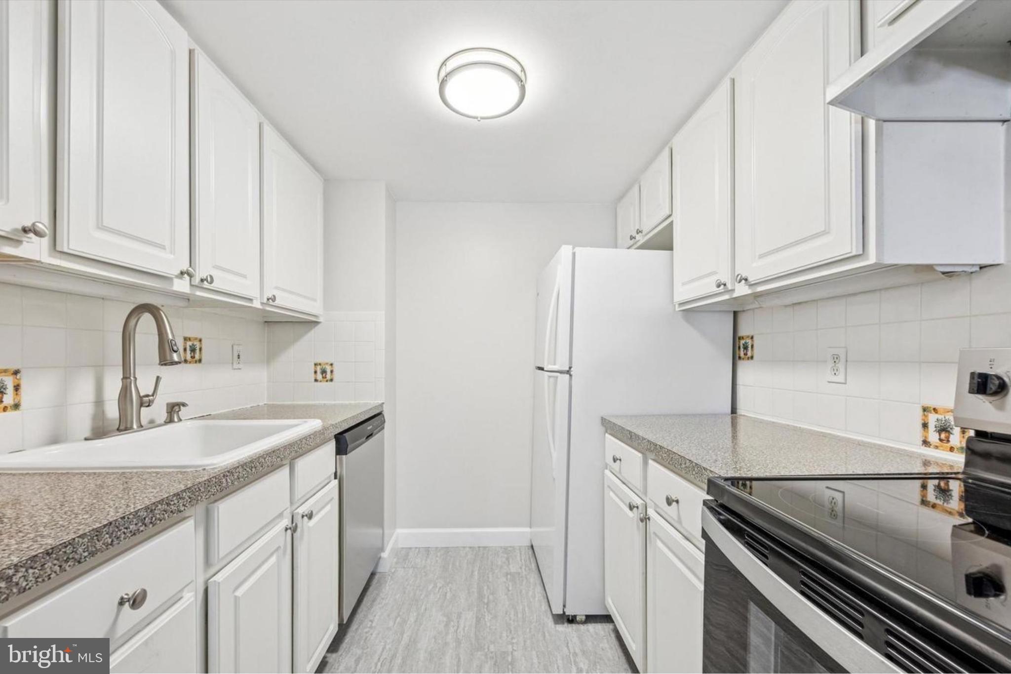 800 Avondale Road, Unit 7B Wallingford, PA 19086 - Photo 15 of 24 a kitchen with stainless steel appliances granite countertop a sink stove and refrigerator
