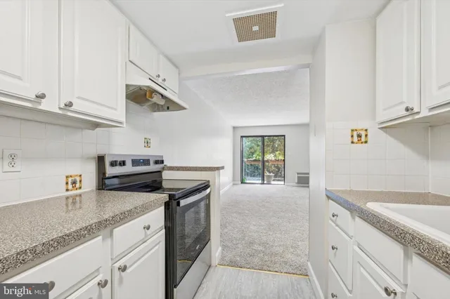 a kitchen with granite countertop a sink stainless steel appliances and cabinets