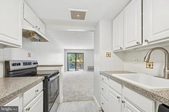 a kitchen with granite countertop a sink stainless steel appliances and cabinets