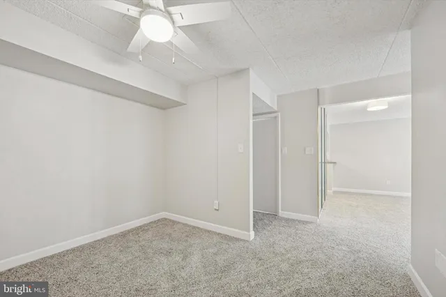 an empty room with a chandelier fan and closet