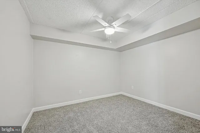 an empty room with a window and ceiling fan