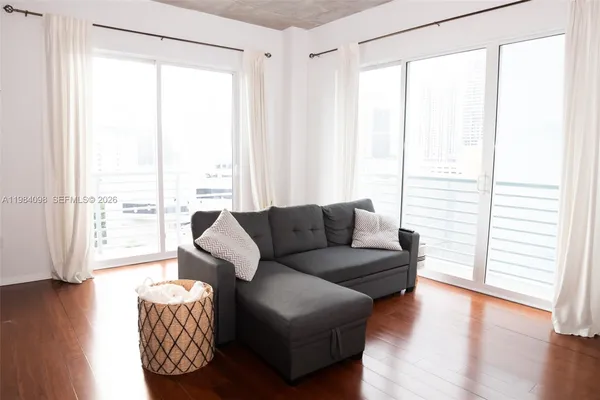 a living room with furniture and a large window with wooden floor