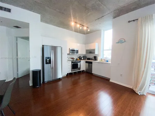 a kitchen with a refrigerator and a stove top oven