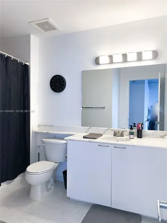 a bathroom with a toilet sink a mirror and shower