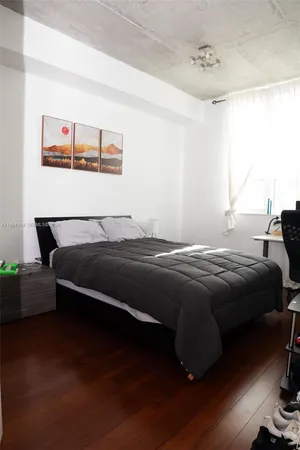 a bedroom with a bed and wooden floor