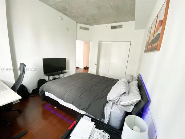 a bedroom with a bed and flat screen tv