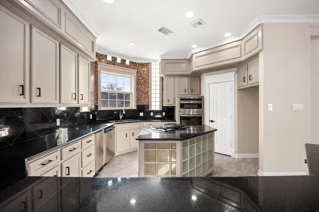 a kitchen with stainless steel appliances granite countertop a sink and cabinets